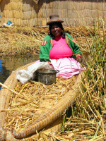 Local woman in traditional totora reed boat, Uros Islands, Peru